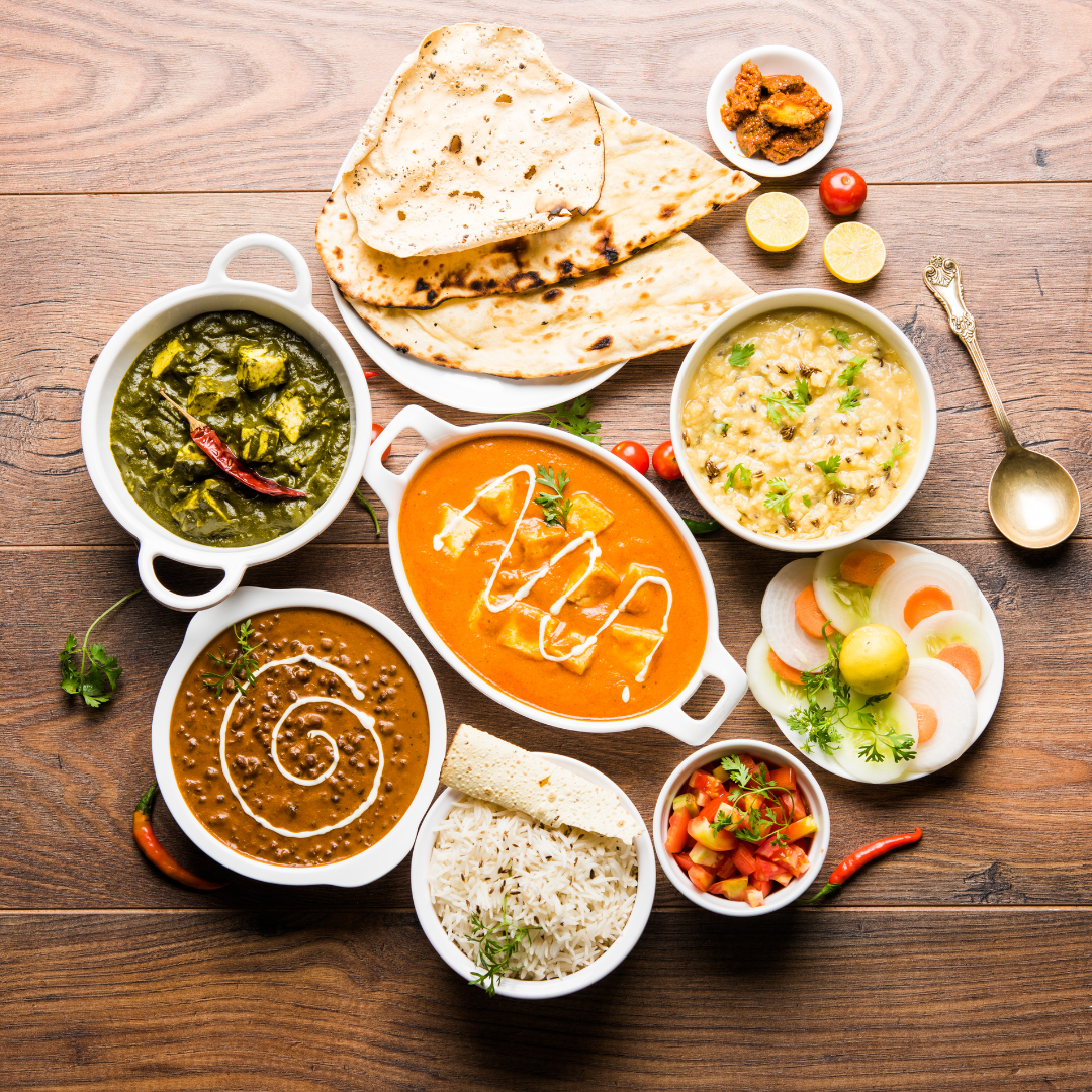 This image shows different Indian dishes, from curries to rice and naans.